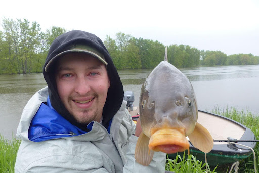 Pêcheur de carpe tenant une carpe